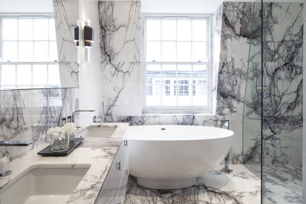 luxurious marble bathroom with marble vanity and round freestanding bath