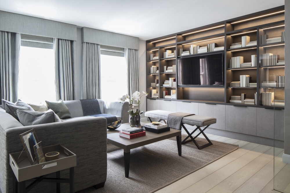 luxurious living room with contemporary grey sofa, grey window treatments and floor-to-ceiling joinery storage