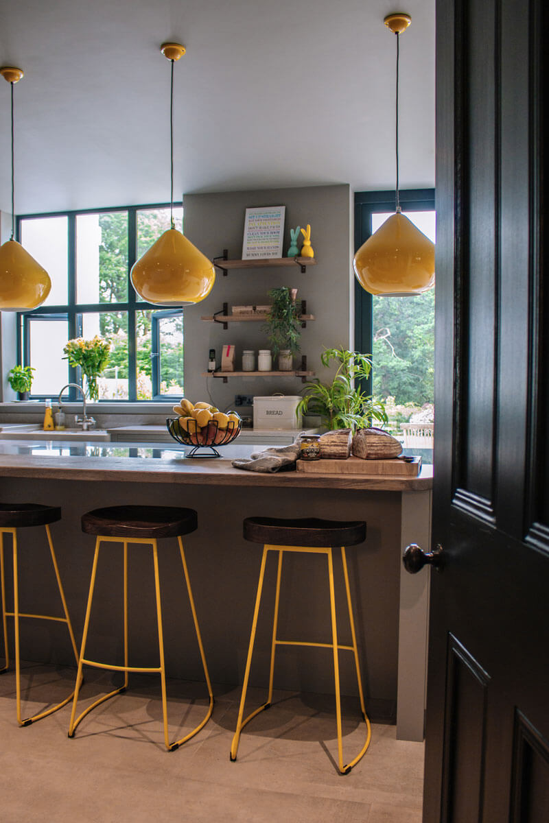 Bespoke kitchen with Island unit and yellow pendant and stools