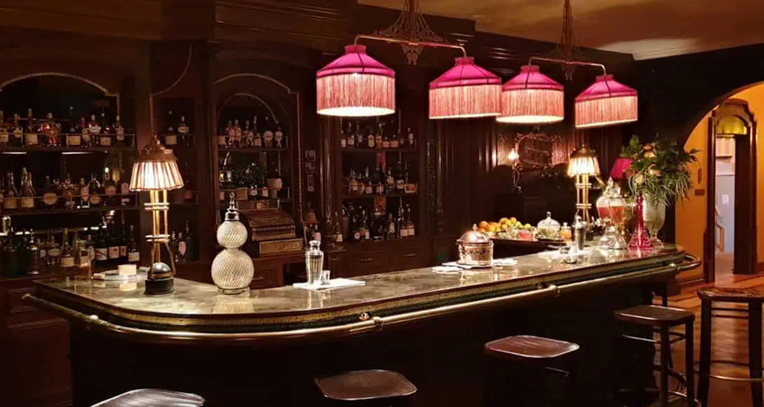 Shelyapin bar scene with silk fringe pendant lampshade shades and a metal / cotton skirt table lamp on the set of A Gentleman in Moscow.  