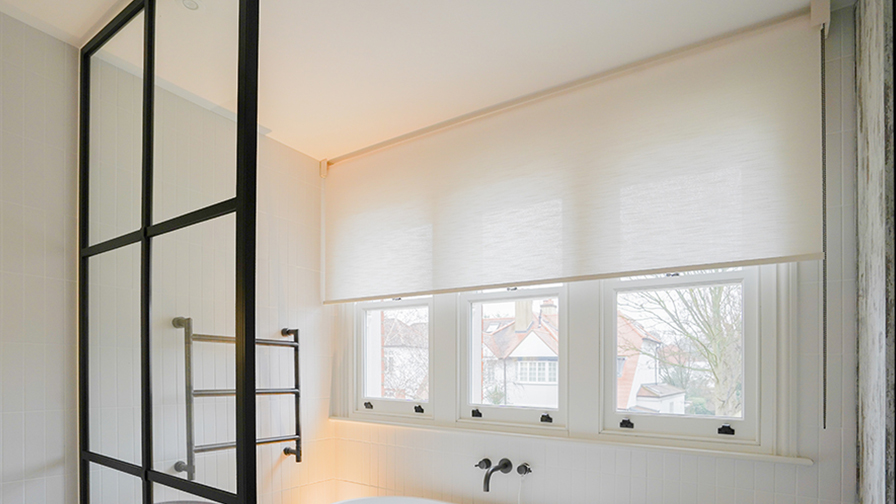 Contemporary bathroom featuring VENESTRE custom roller blinds in a soft, light-filtering fabric. The window treatments are installed above a sash window, delivering privacy and a refined finish, representative of VENESTRE’s bespoke solutions for luxury interiors.