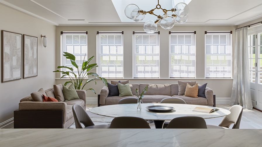 Spacious orangery featuring VENESTRE custom roller blinds with a delicate sheer fabric, installed on multiple windows. 