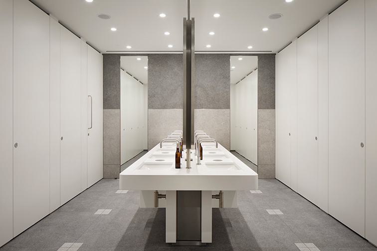 A group of sinks centred to the image, with doors on the left and right of the image