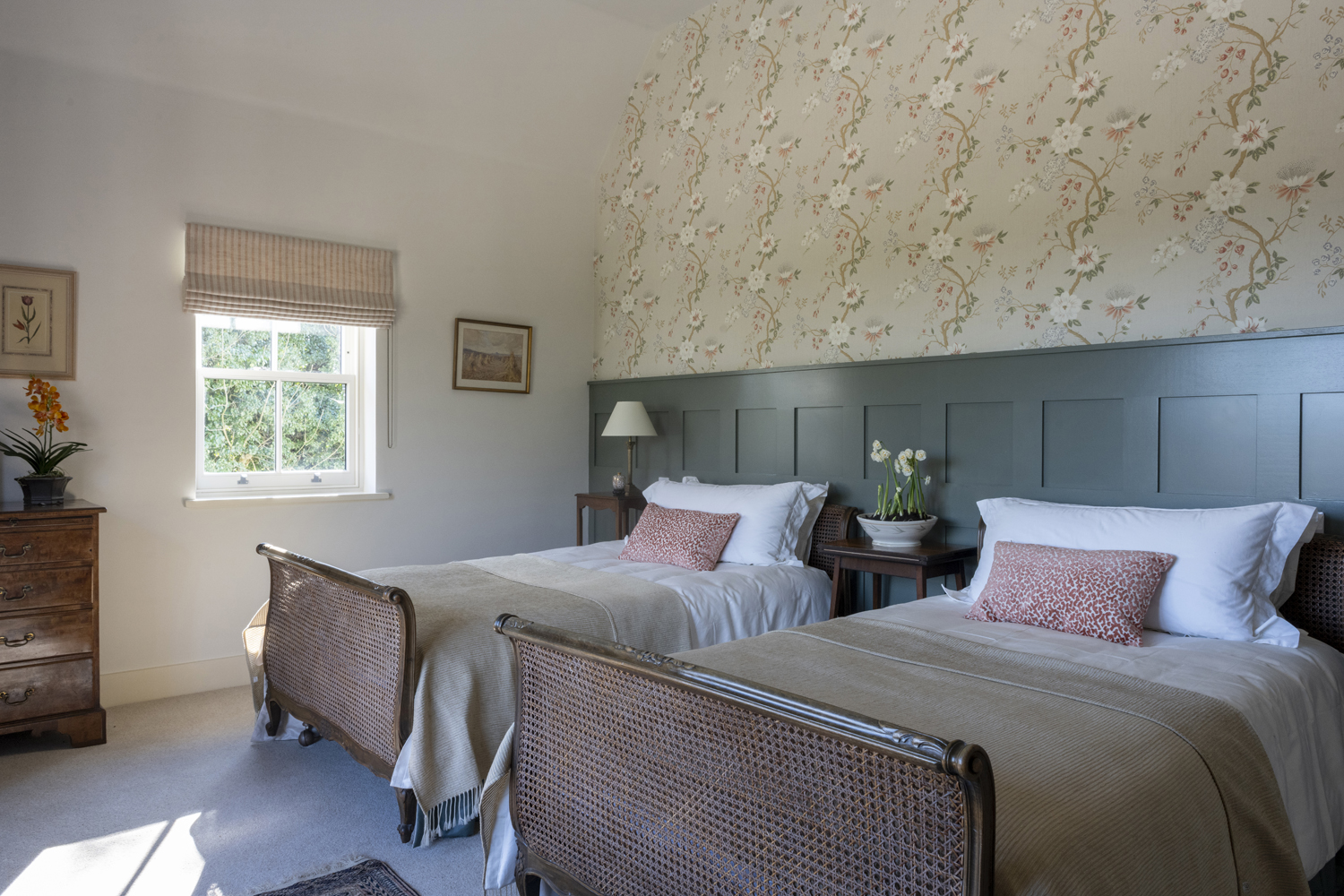 Twin beds in green wall panelled guest bedroom