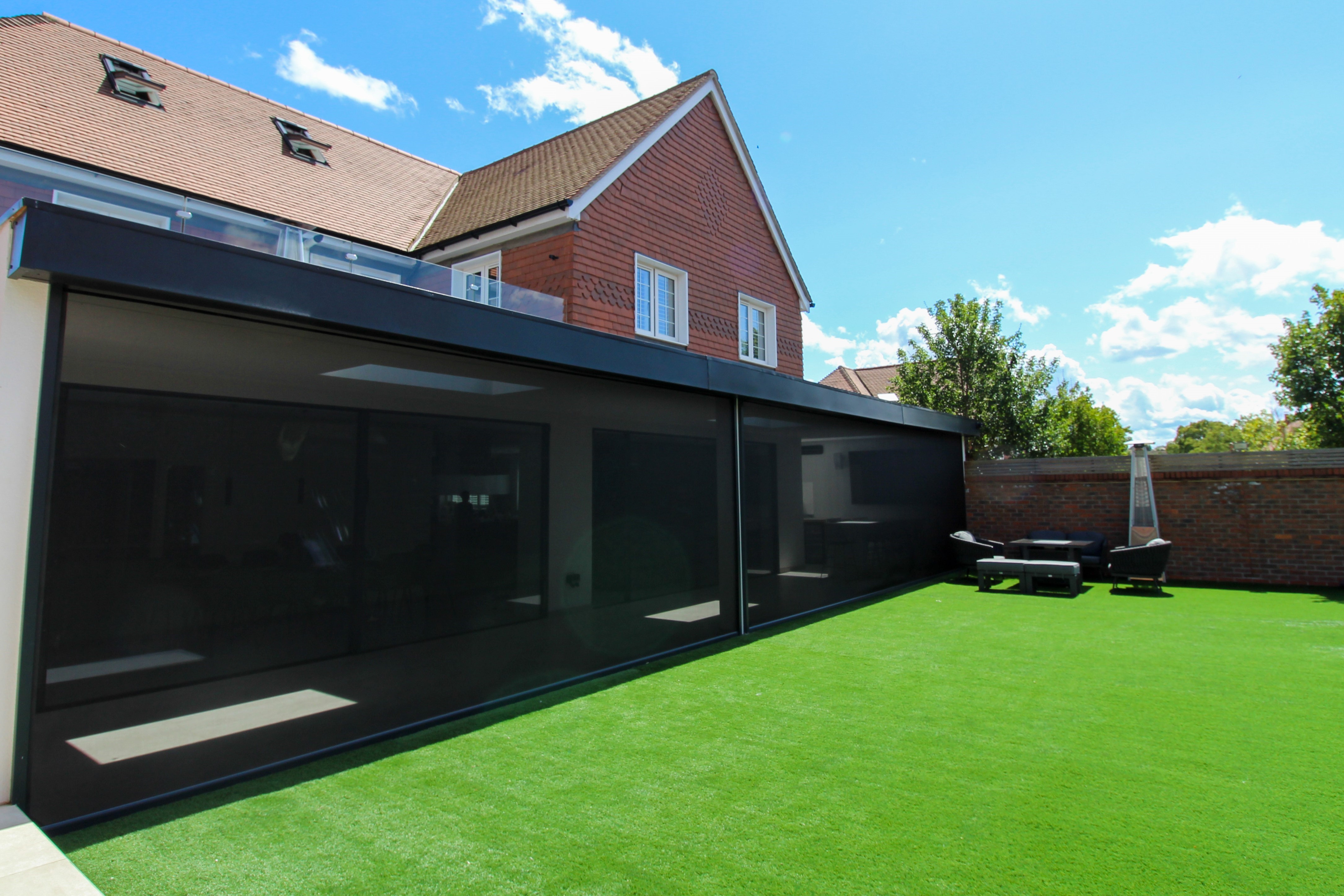 Exterior view of automated solar screens extending over large windows, reducing heat and glare