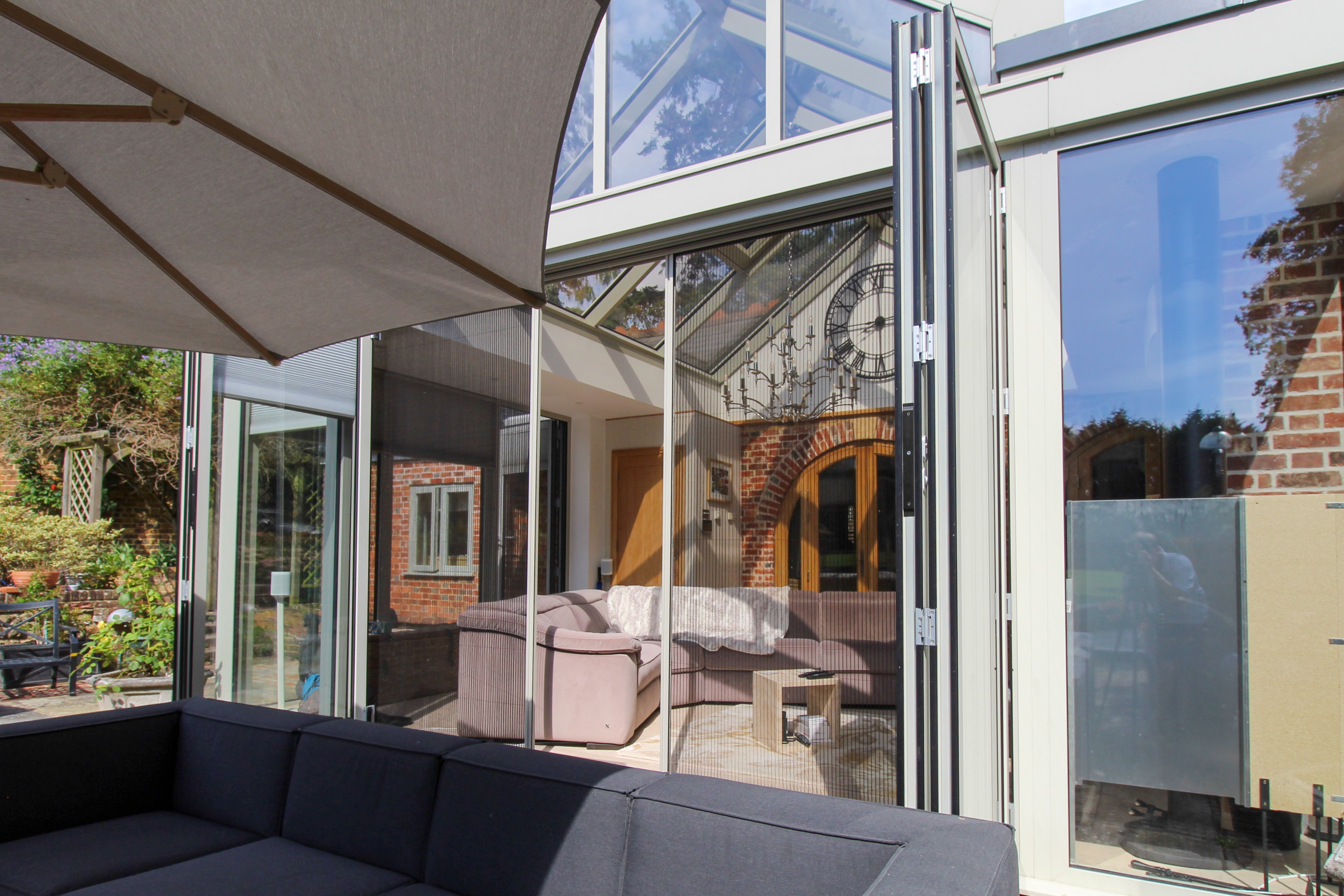 Glass extension enjoys natural ventilation thanks to our pleated door screens