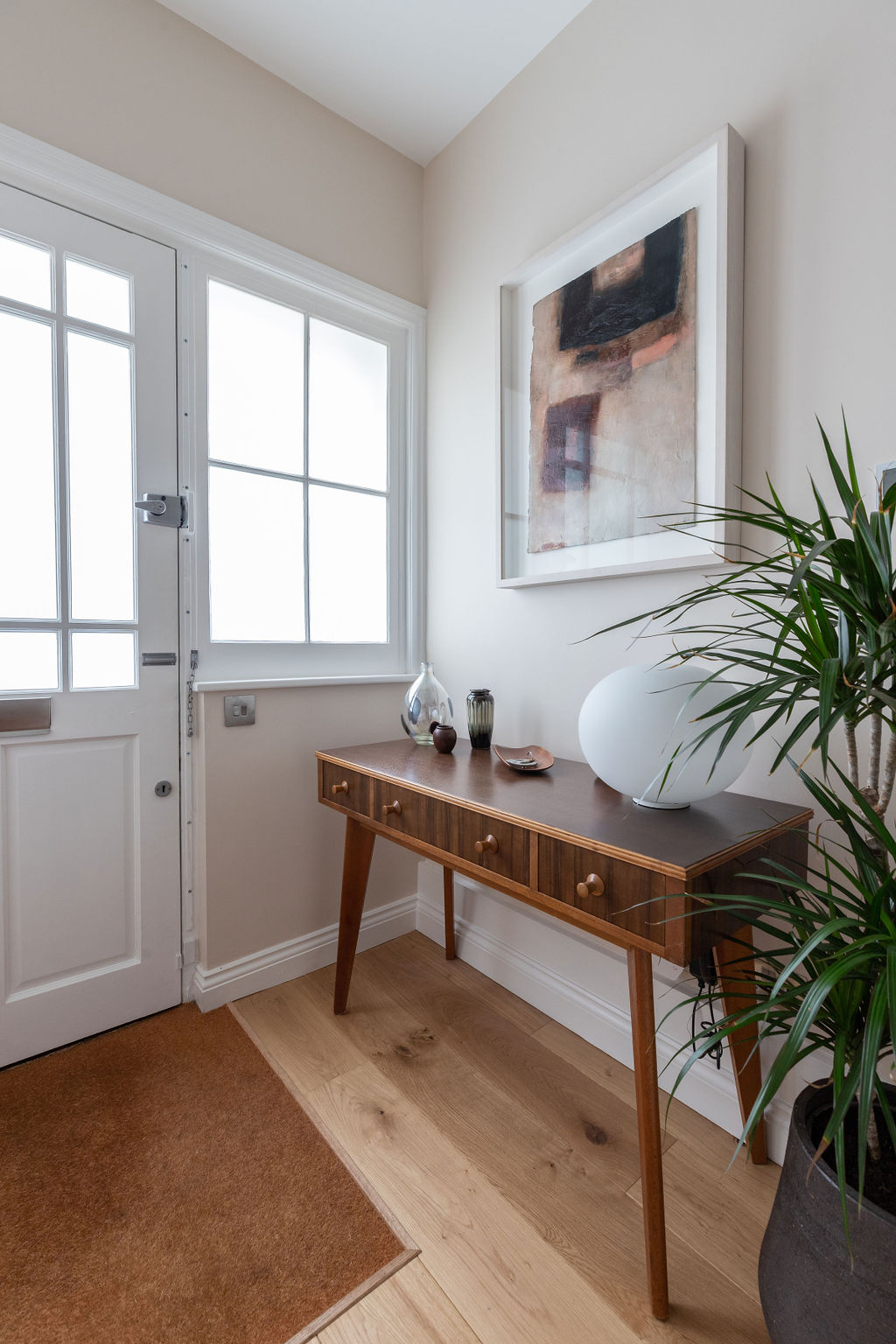Front door with hall console table with light and plant