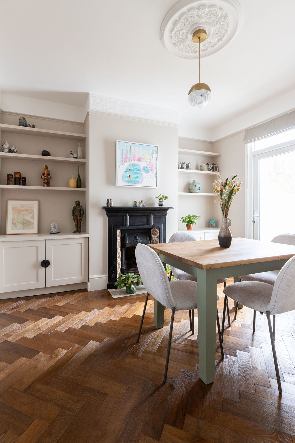 Beautiful dining room with parquet flooring, bespoke joinery in the alcoves, traditional mouldings and wooden table with chairs 