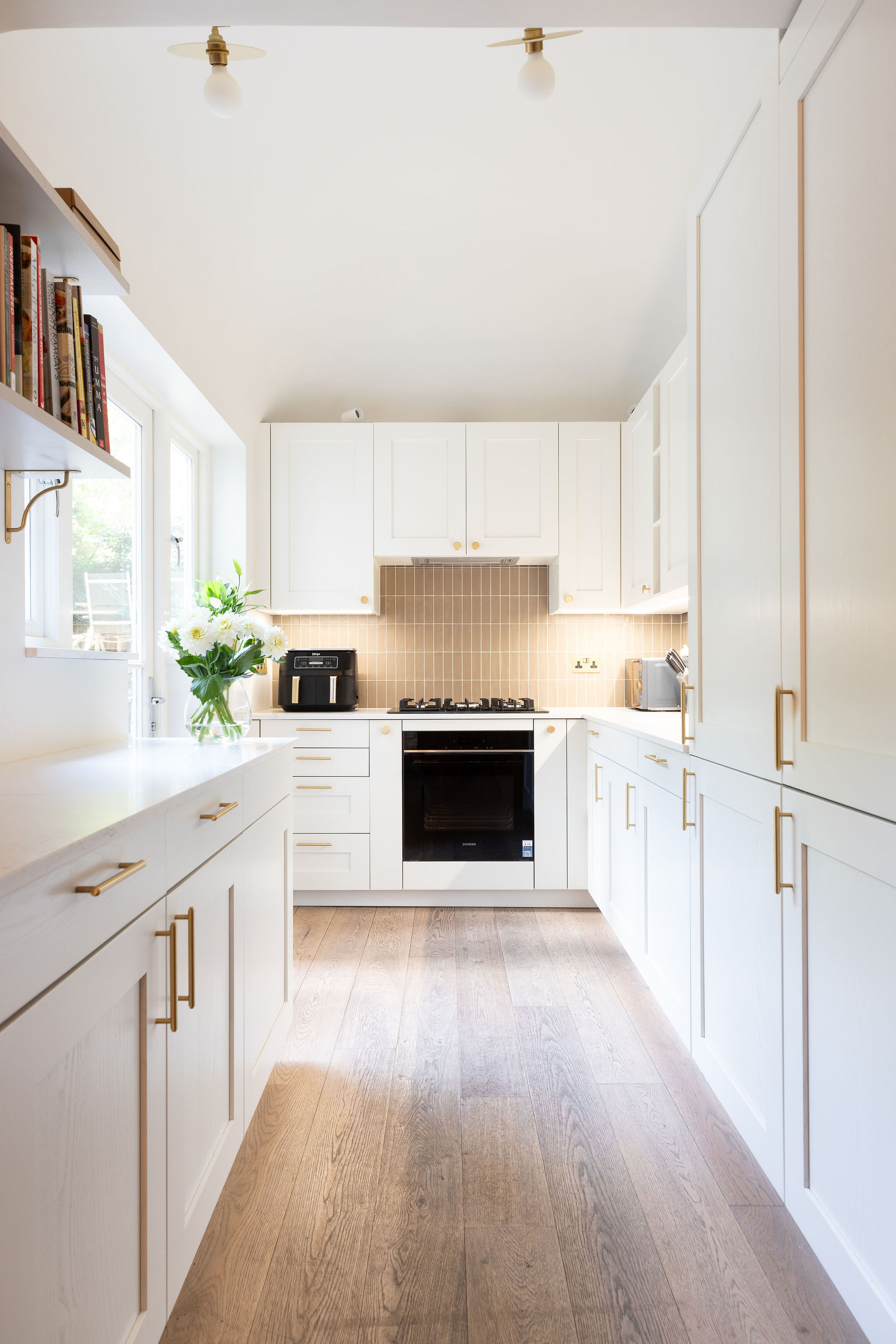 Chic white minimalist kitchen with wooden floors