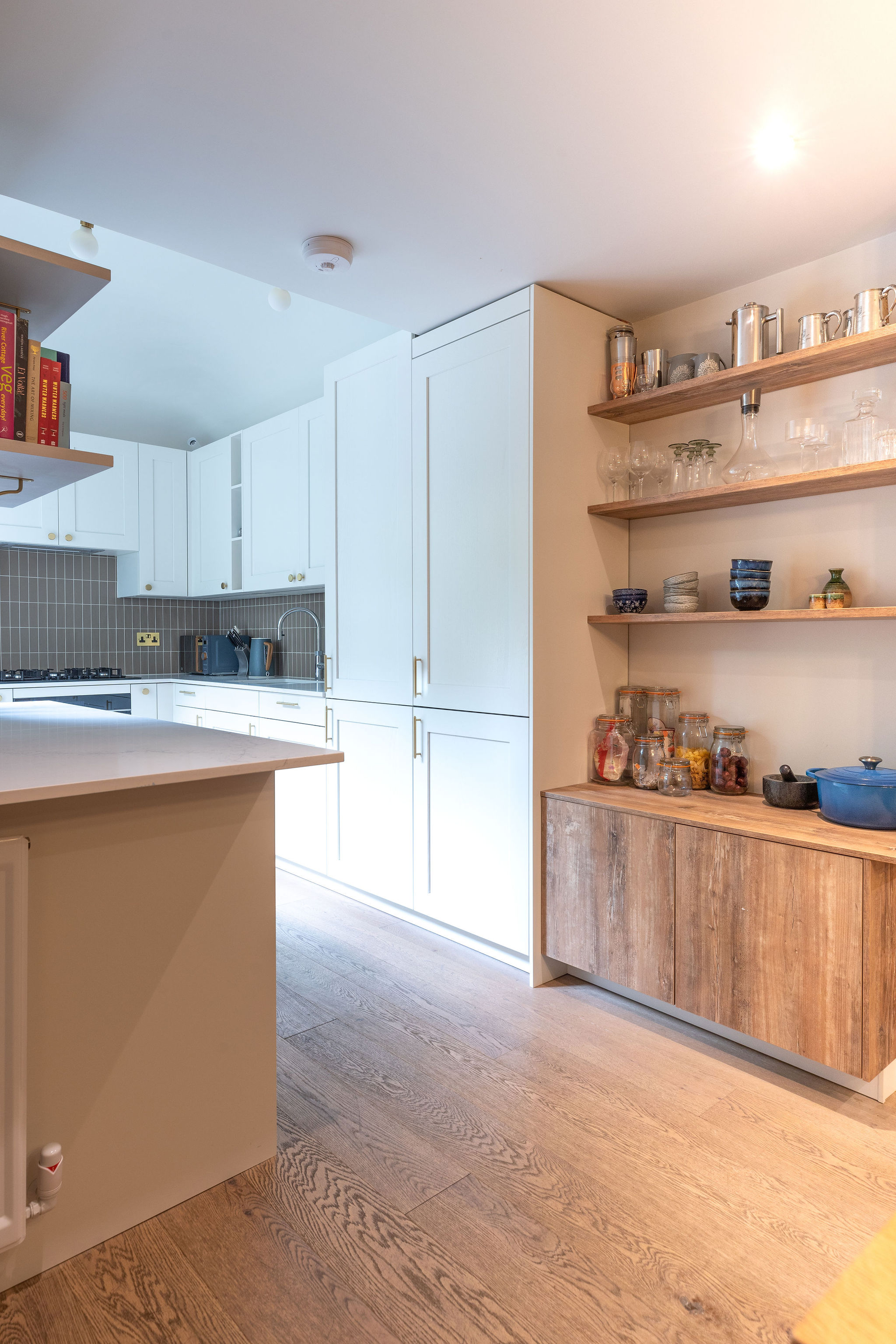White kitchen meets wooden unit and shelves 