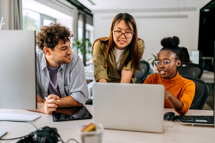 three young people around a laptop