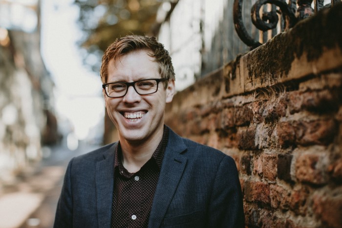 smiling man in glasses.