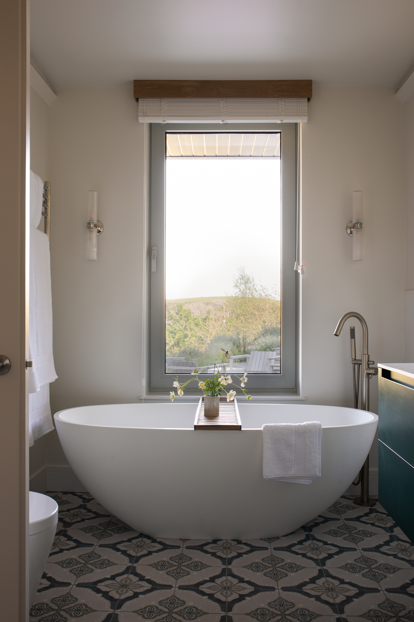 Refined bathroom within a contemporary riverside new build, fully designed and detailed as part of a high-end, turnkey interior architecture project with freestanding bath and bespoke finishes.