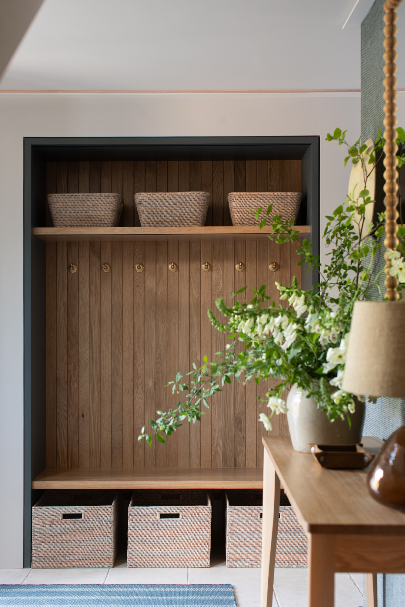 Custom built-in storage within a contemporary riverside new build reception room, designed as part of a high-end, full turnkey interior architecture and furnishing project.