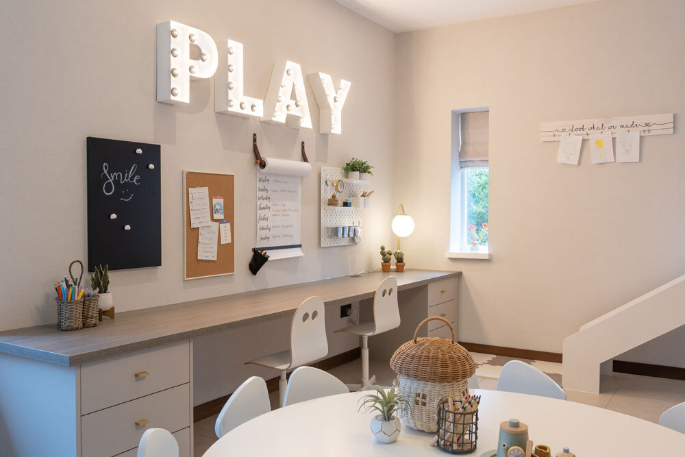 Playroom with neon PLAY sign and desk