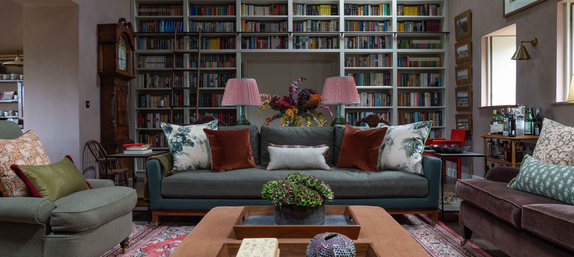 Living area with bookshelf behind set of sofas