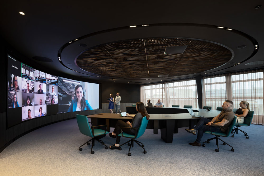 Large round table with large screen behind.