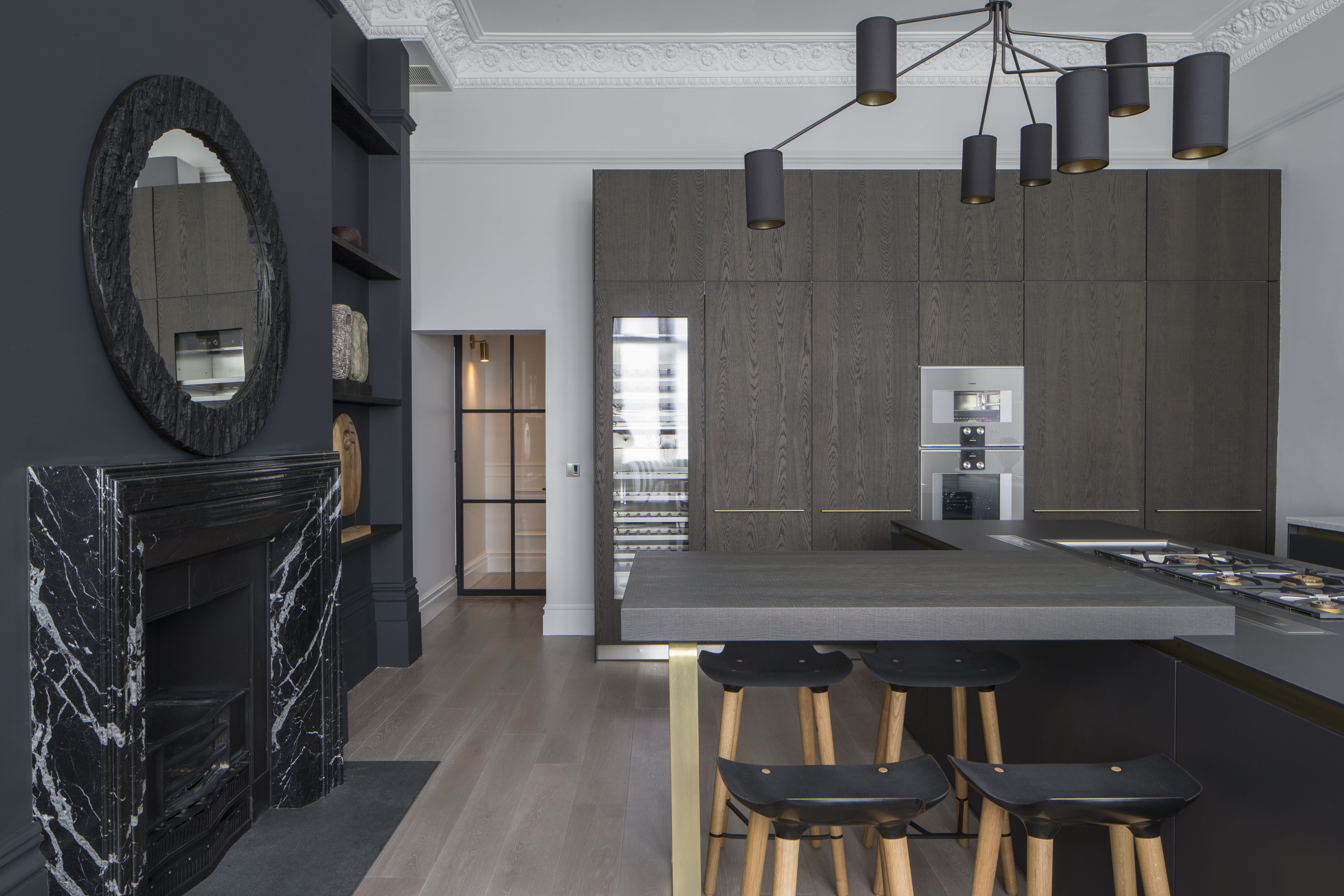 contemporary monochrome kitchen with marble fireplace surround, kitchen island and tall timber cabinetry