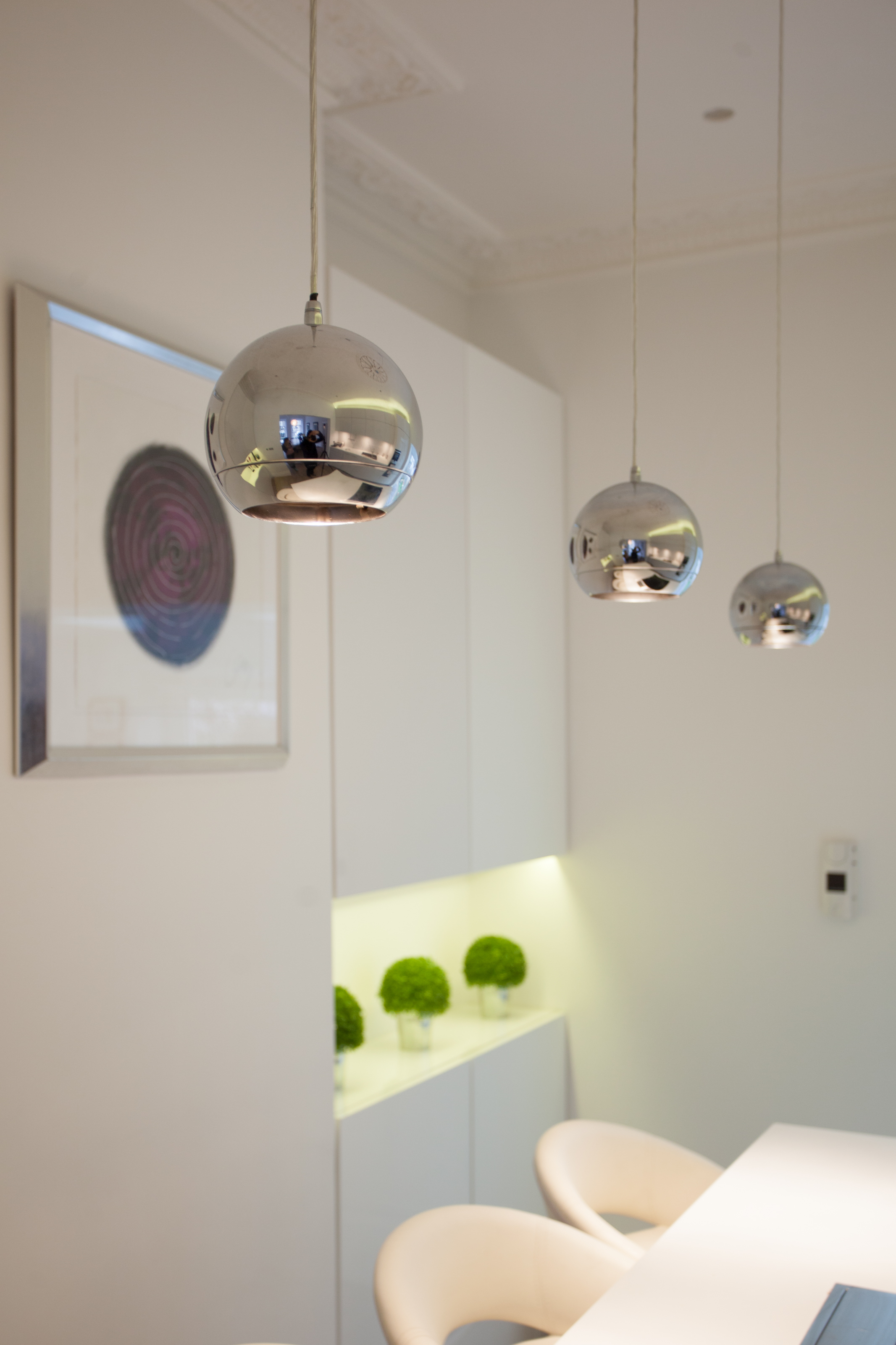 contemporary white kitchen island with pendant lights above kitchen island and contemporary artwork
