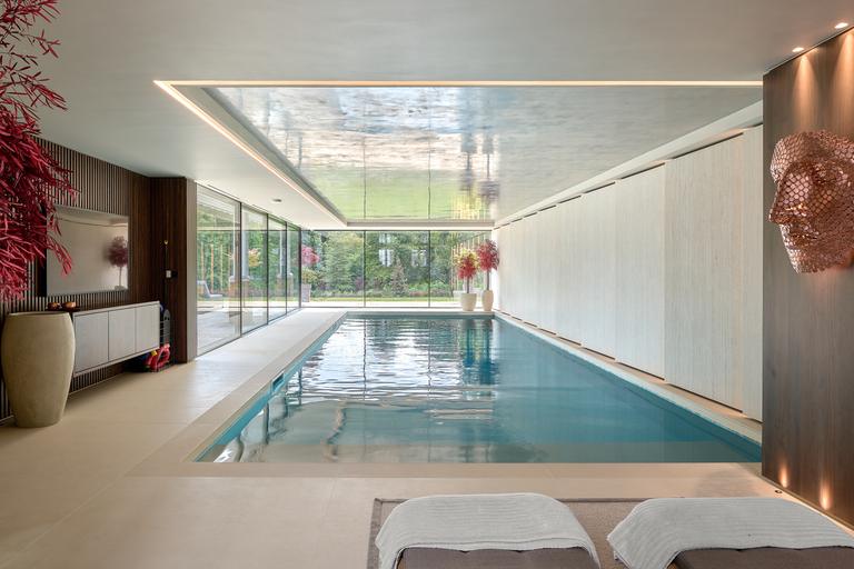 Indoor swimming pool with glass wall at the end of the room